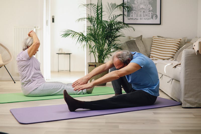 Active seniors doing yoga at home - hydrogen therapy supports daily wellness